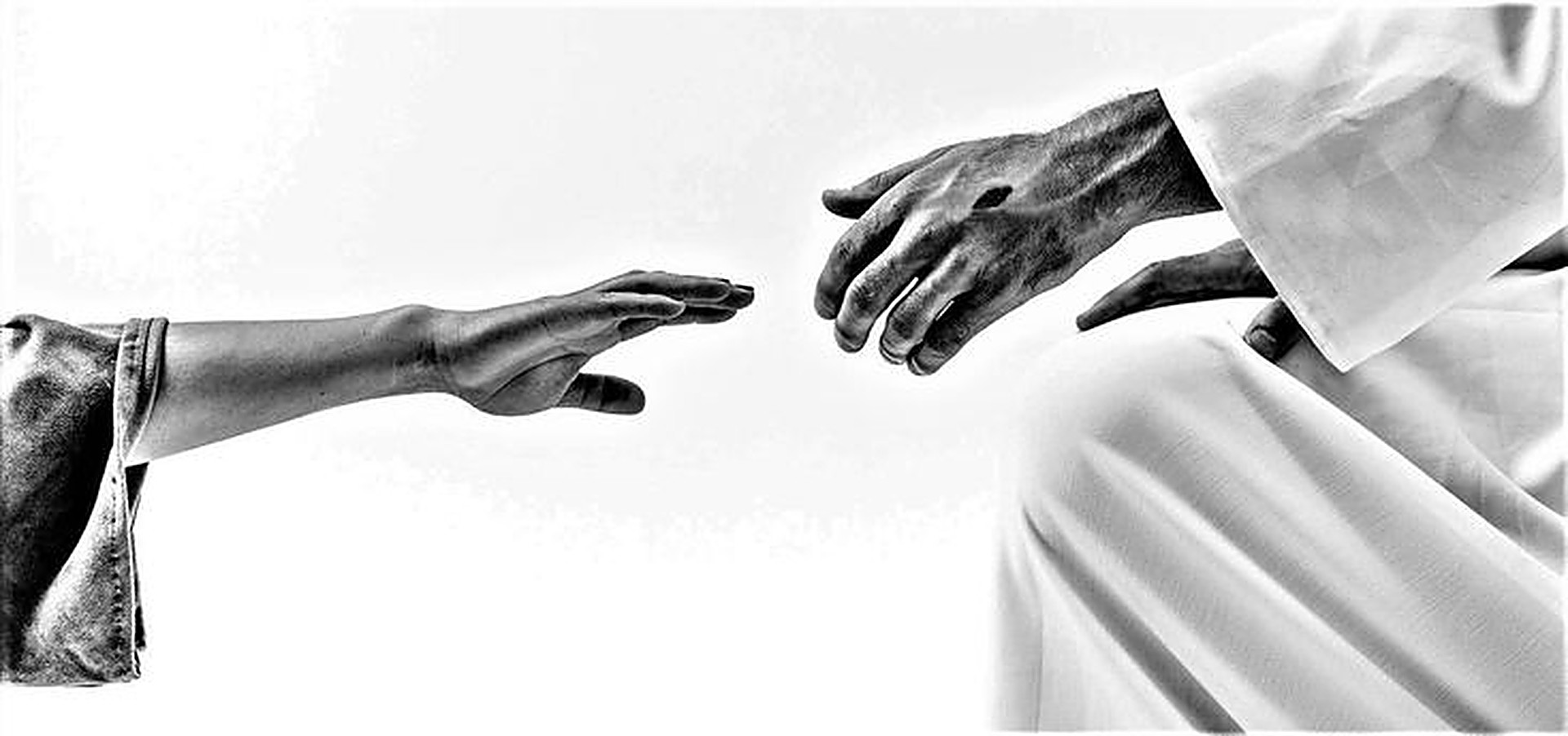 A hand reaching toward the hand of Christ